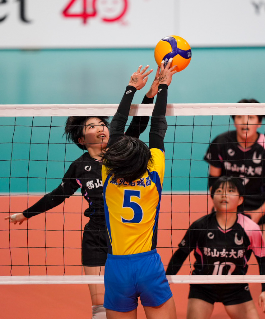 女子1回戦　郡山女大付対鹿児島城西　第1セット　スパイクを放つ郡山女大付・佐藤（奥）（撮影・小島史椰）