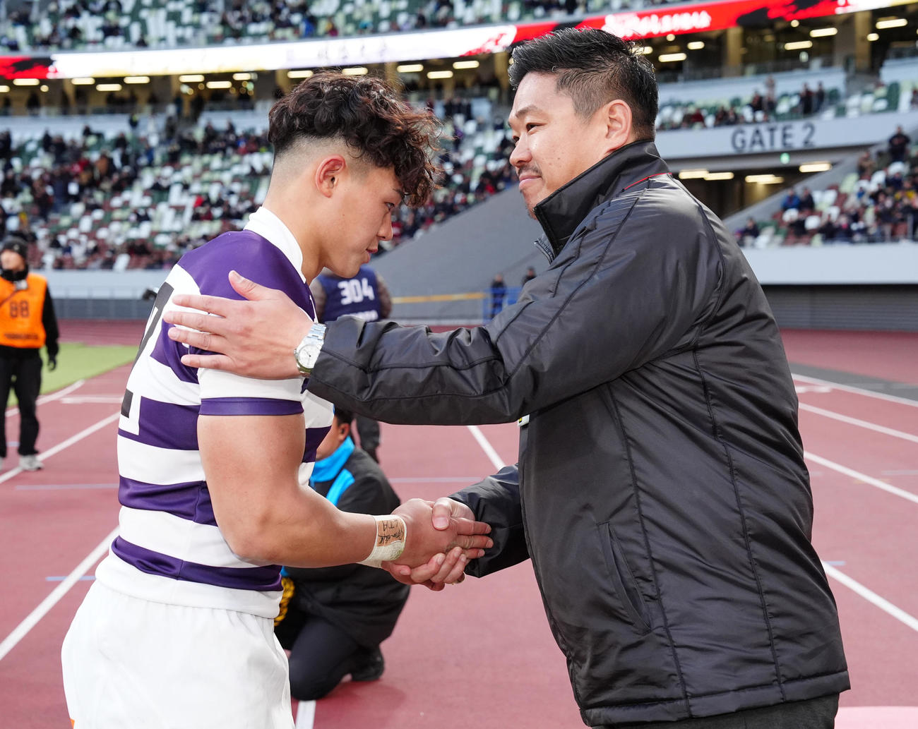 明大対早大　優勝した明大・平（左）と握手を交わす早大・大田尾監督（撮影・鈴木みどり）