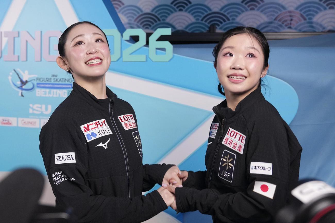 優勝を決め、2位の中井亜美（右）と手を取り合い涙する青木祐奈＝北京（共同）