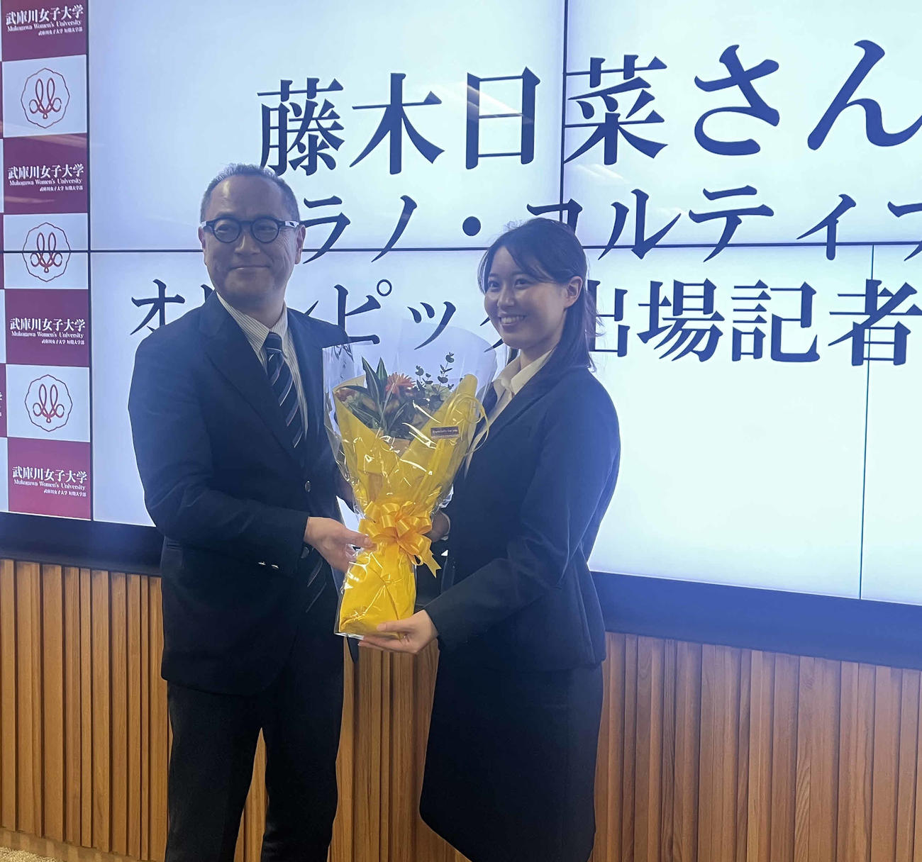 花束を渡す武庫川女大競技スキー部の渡辺昌史部長（左）と藤木日菜（撮影・竹本穂乃加）