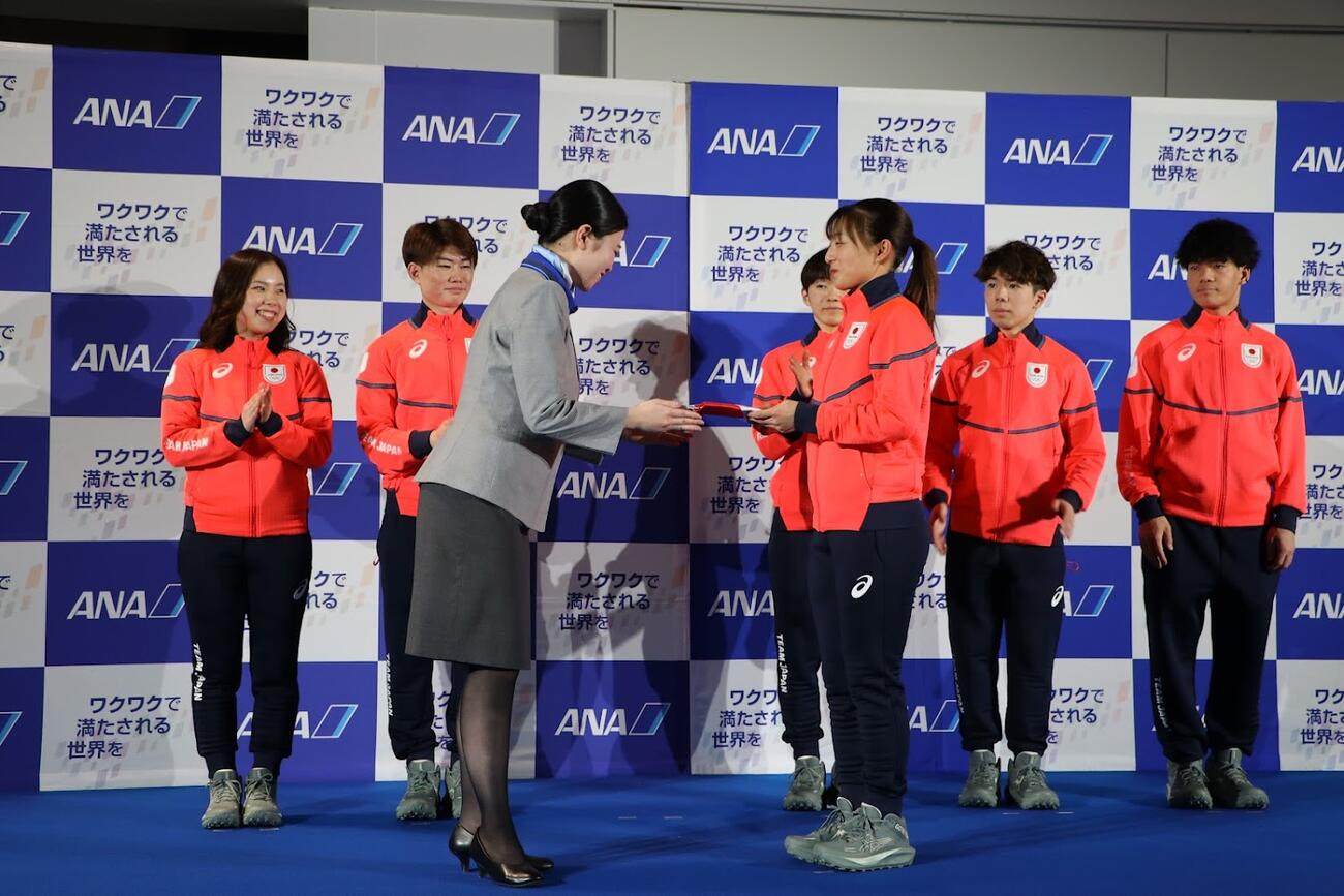 ミラノ・コルティナ五輪に向けての出発前に、ANAの職員からプレゼントをもらう坂本花織（同社提供）