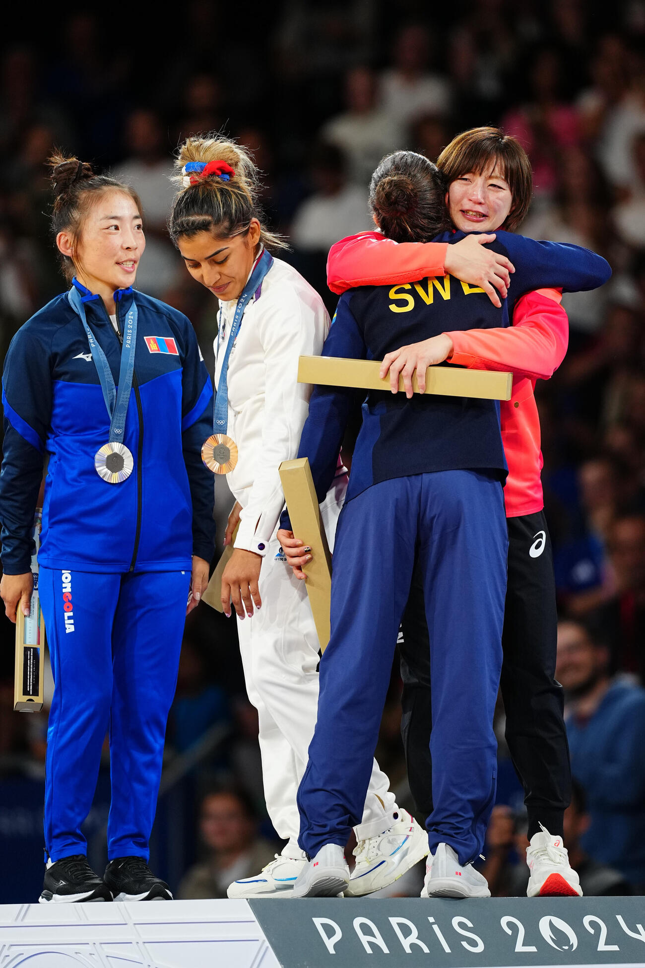 金メダルの角田夏実（右）は表彰台で涙を流しながらライバルたちと抱擁（2024年7月）