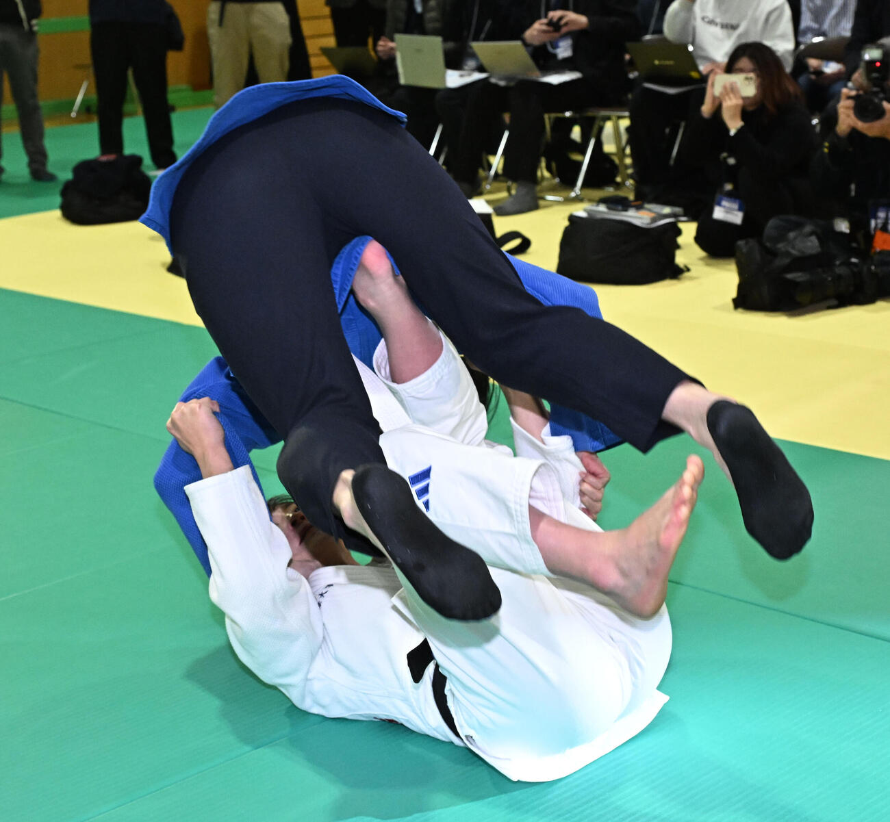 記者会見の会場にサプライズで訪れた今井コーチ（上）に巴投げをかける角田（撮影・千葉一成）