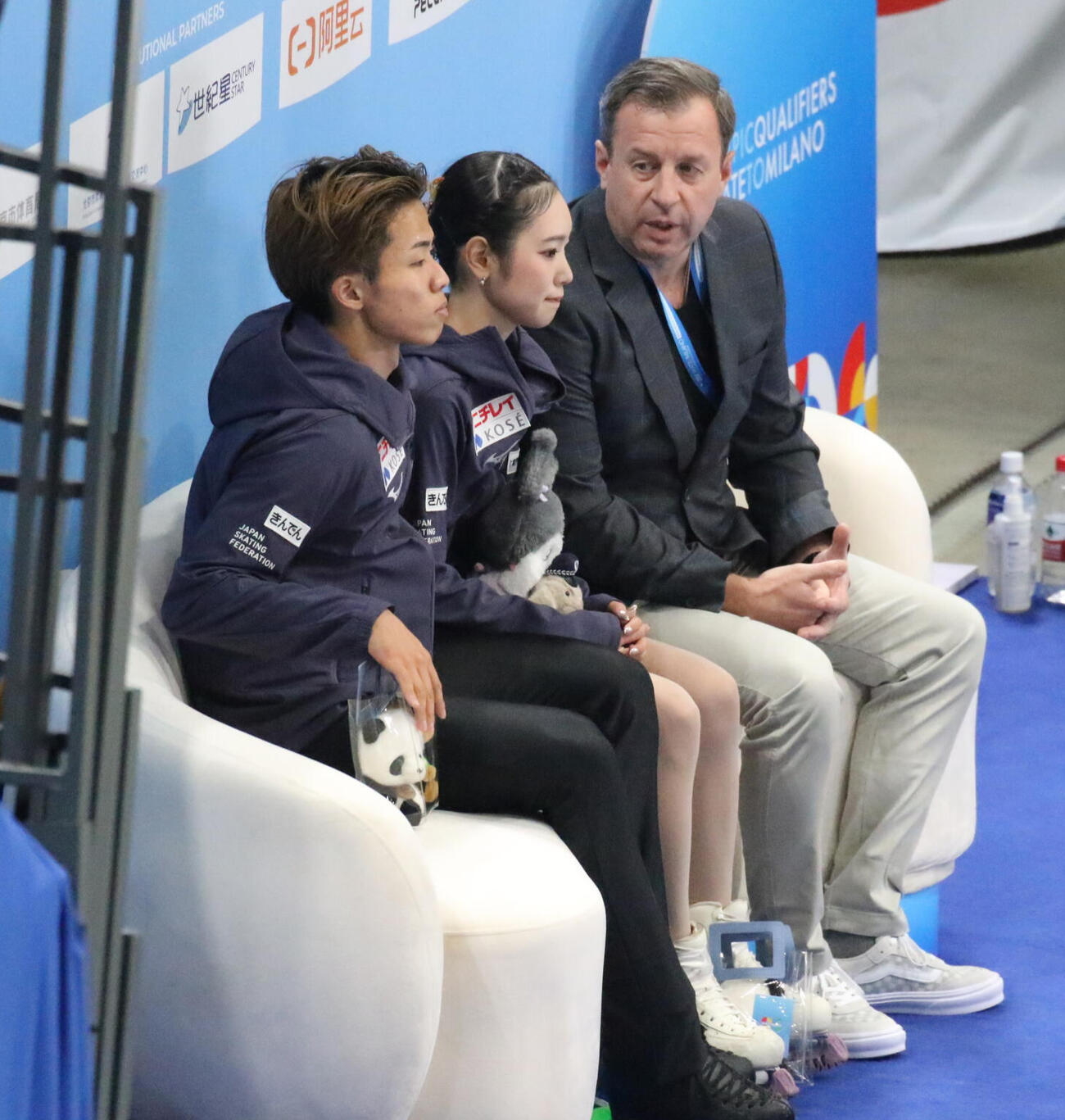 ミラノ・コルティナ冬季五輪最終予選ペアフリー　演技を終えてドミトリー・サビン・コーチ（右）と話す長岡柚奈（中央）、森口澄士（2025年9月20日撮影）
