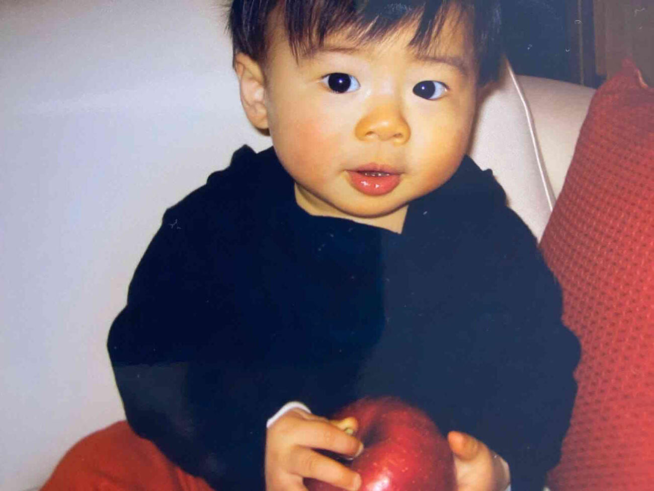 1歳のころ、リンゴを手に持つ佐藤駿（本人提供）