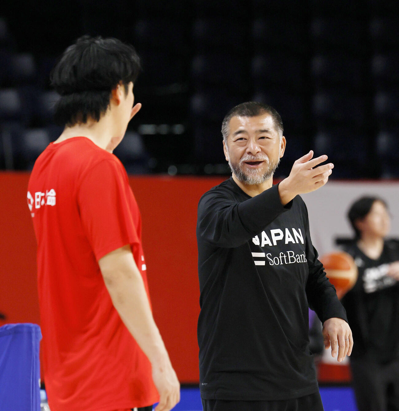 中国戦に向けた調整で安藤（左）と話す桶谷監督＝沖縄サントリーアリーナ（共同）