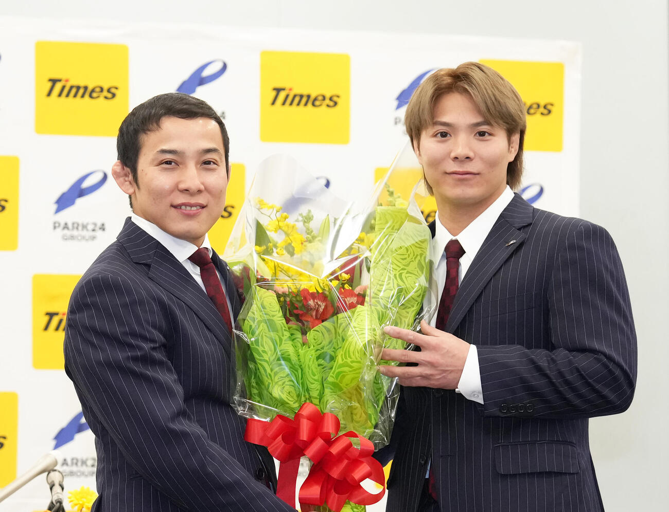 引退会見を終えた高藤（左）は阿部から花束を受け取り笑顔（撮影・足立雅史）