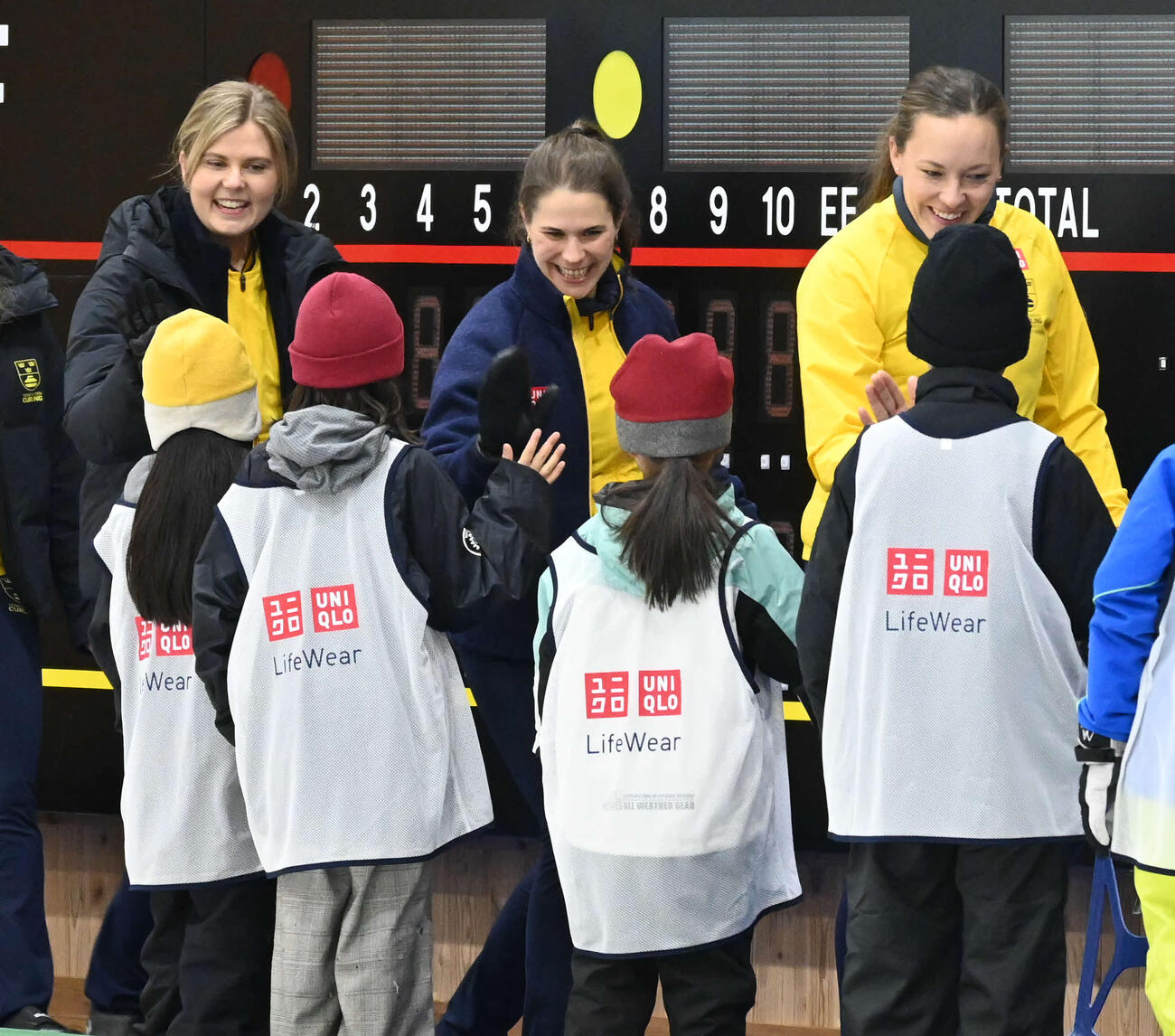 子どもたちとハイタッチするハッセルボリ（中央）ら女子カーリングスウェーデン代表（撮影・飯岡大暉）