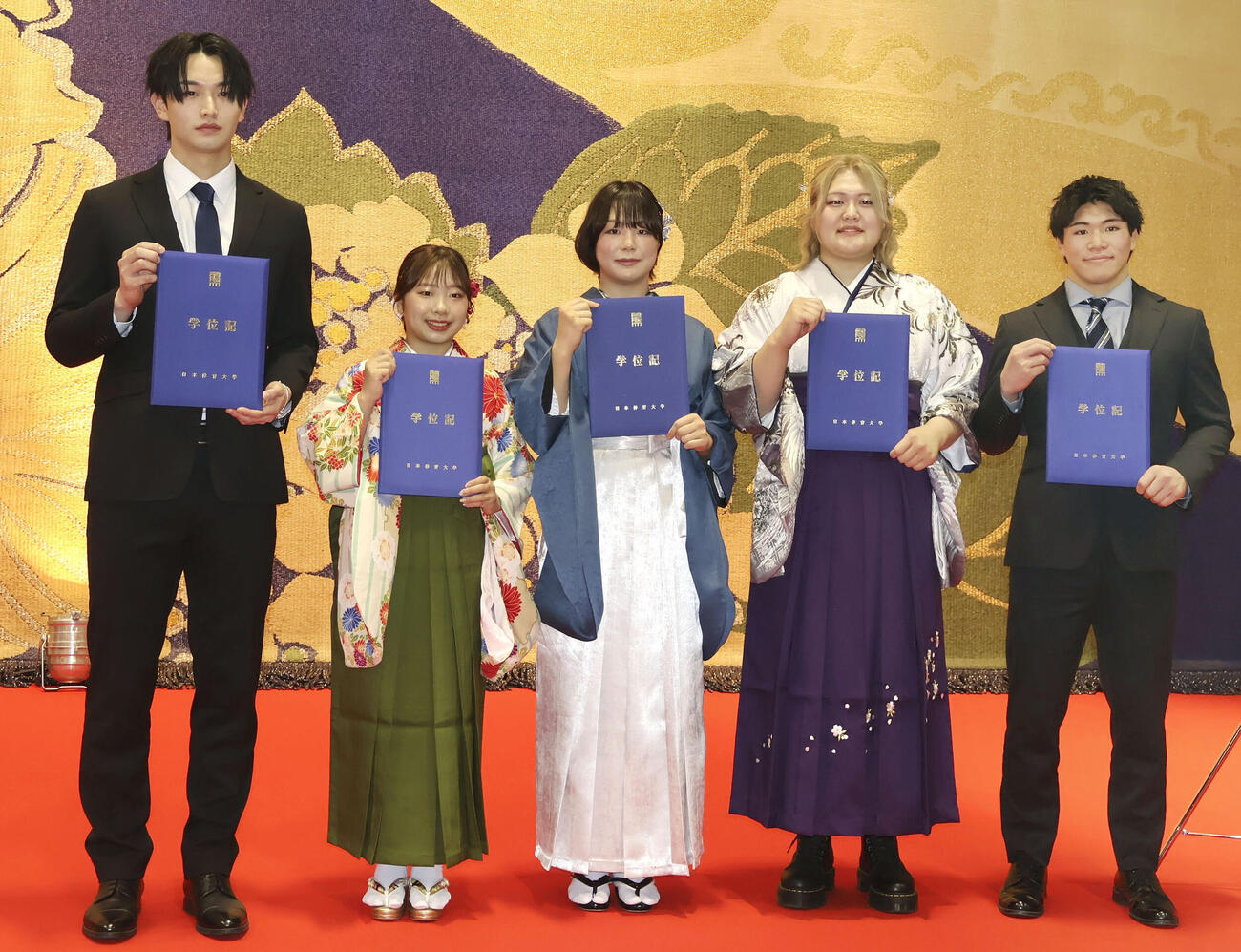 日体大の卒業式に出席後、写真撮影に応じるレスリング女子の藤波朱理（中央）。右から2人目は柔道女子の新井万央