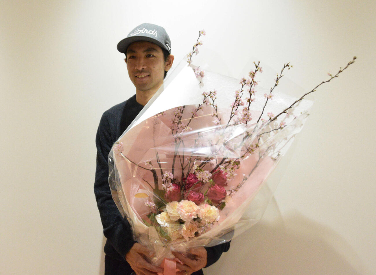 帰国後、花束を受け取った渡部（撮影・泉光太郎）