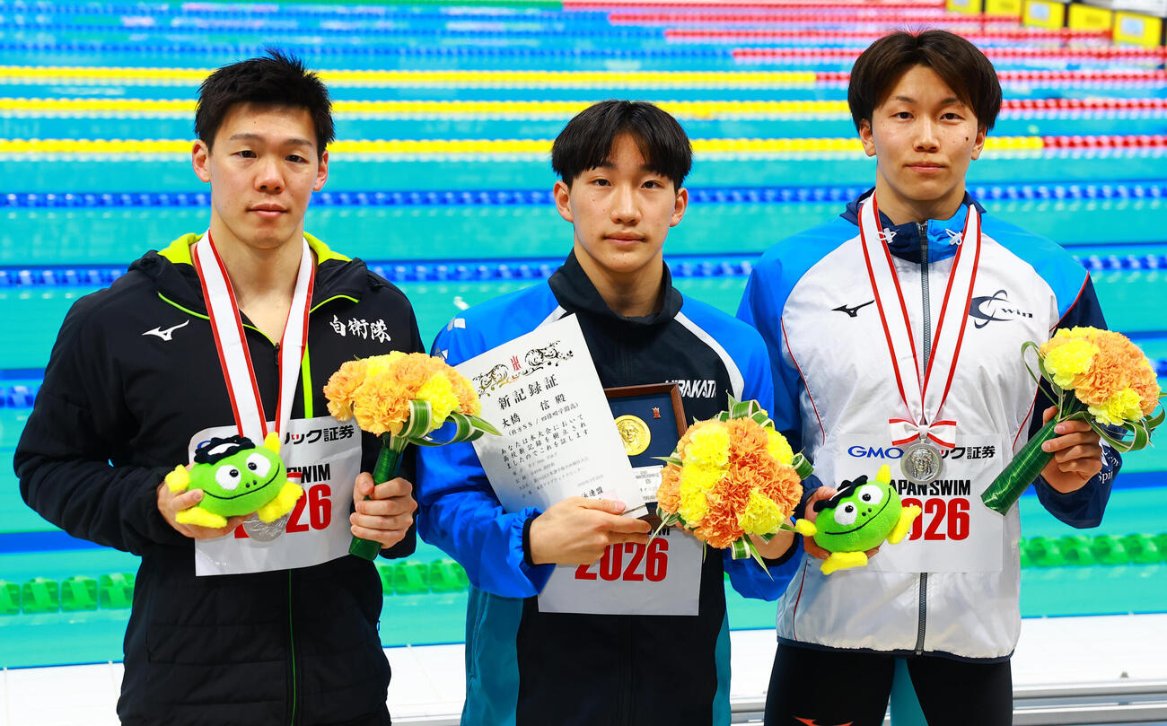 男子50メートル平泳ぎで優勝した大橋（中央）は、2位の渡辺（左）、3位の柳沢と記念撮影（撮影・野上伸悟）