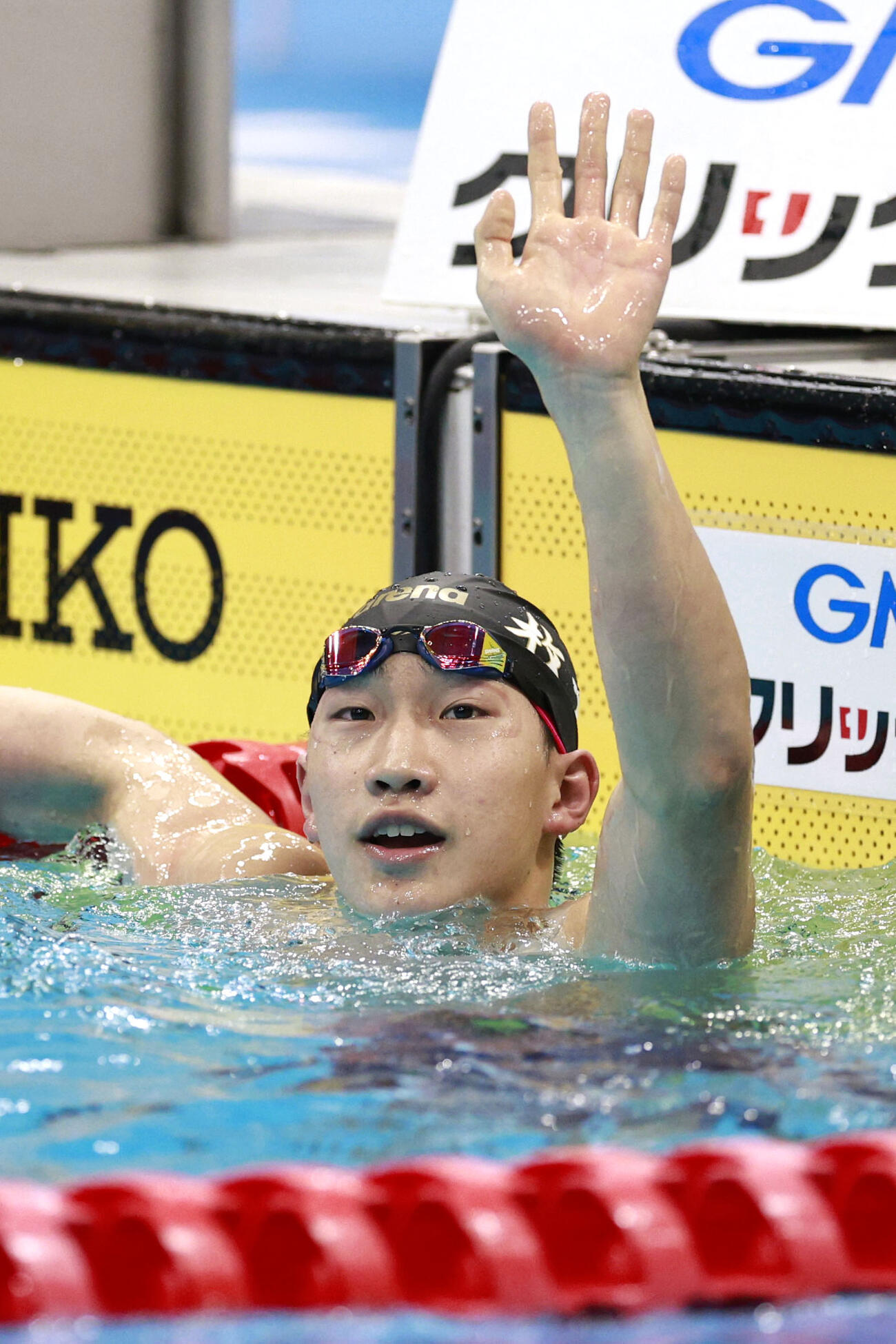 男子50メートル平泳ぎ決勝のゴール後、声援に応える大橋信（共同）