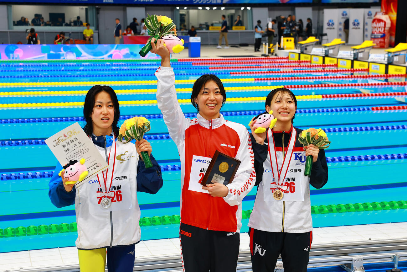 女子100メートル平泳ぎで優勝し喜ぶ鈴木（中央）。左は2位の加藤、右は3位の小畠（撮影・野上伸悟）