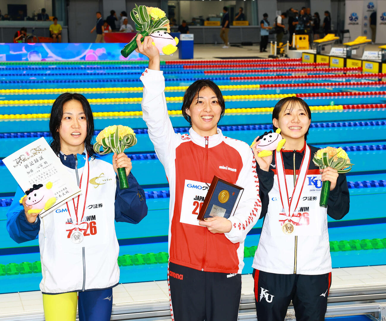 女子100メートル平泳ぎで優勝し喜ぶ鈴木（中央）。左は2位の加藤、右は3位の小畠（撮影・野上伸悟）