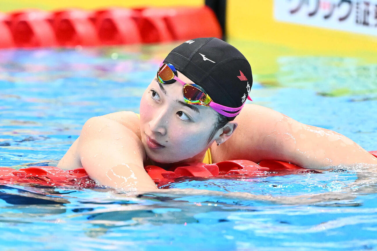 女子50メートルバタフライで優勝を決め電光掲示板を見る池江（撮影・滝沢徹郎）
