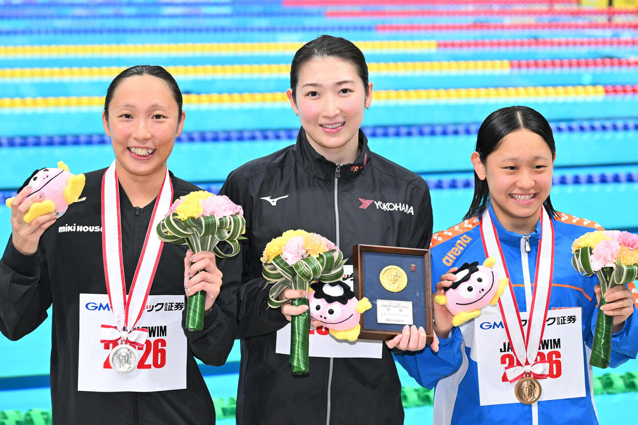 女子50メートルバタフライの表彰式を終え記念撮影する優勝の池江（中央）。左は2位の相馬と3位の清水（撮影・滝沢徹郎）