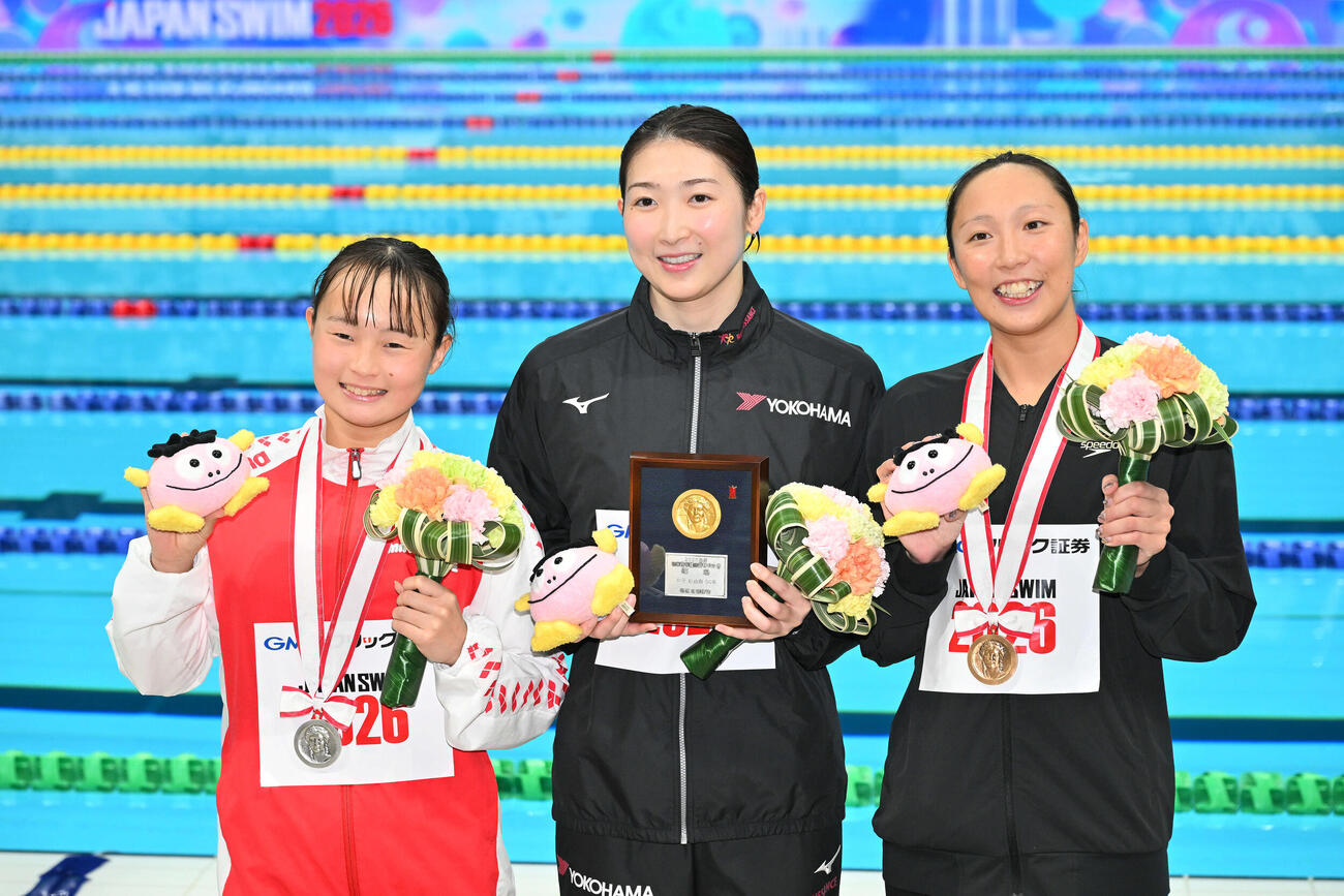女子50メートル自由形で優勝し記念撮影する池江（中央）。左は2位の神野と3位の相馬（撮影・滝沢徹郎）