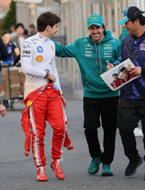 パドックで笑顔を見せるアストンマーティンホンダのアロンソ。左はフェラーリのルクレール（撮影・宮崎幸一）