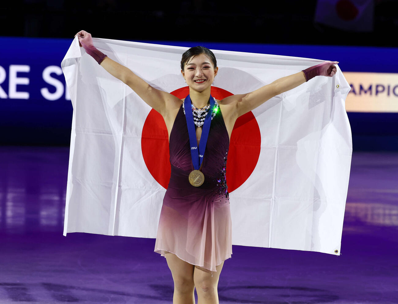 フィギュア世界選手権　今大会限りで現役引退の坂本花織は総合優勝を飾り、日の丸を掲げて笑顔で記念撮影（撮影・PNP）