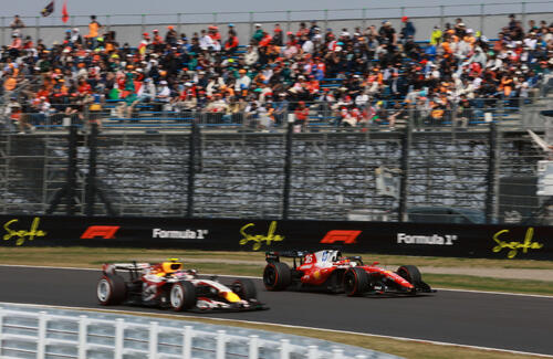 スタンドをバックに1コーナーに入るレーシングブルズのローソン（左）とフェラーリのルクレール（撮影・宮崎幸一）