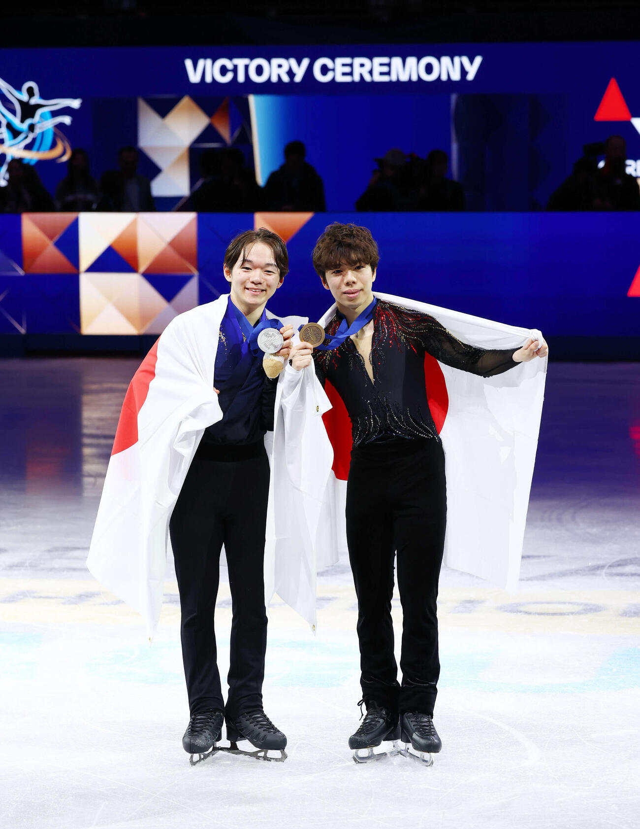 フィギュア世界選手権　男子総合で2位の鍵山優真（左）と3位の佐藤駿は日の丸を背に記念撮影（撮影・PNP）