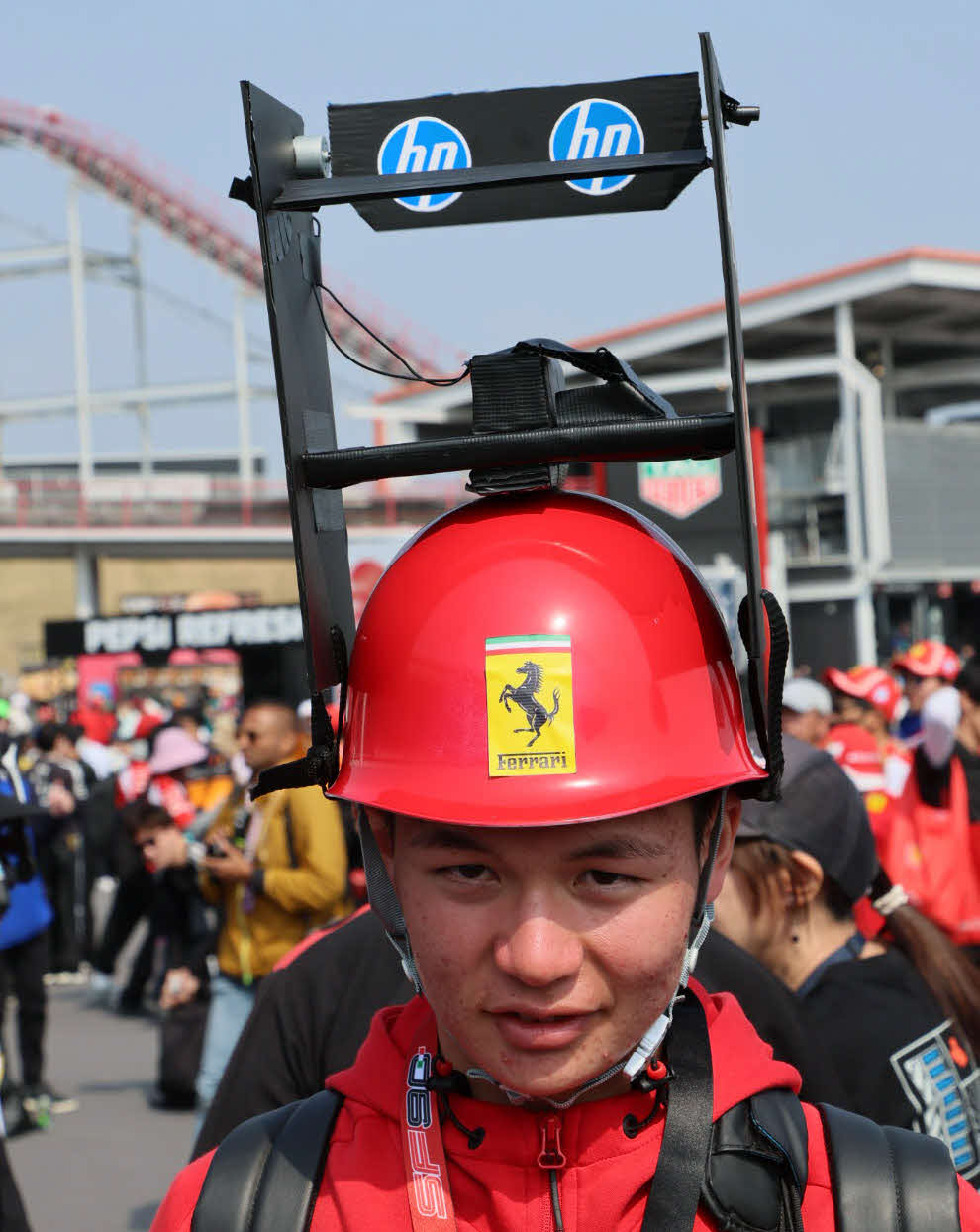今年流行の回転するフラップのウィング付きヘルメットでアピールするファン（撮影・宮崎幸一）