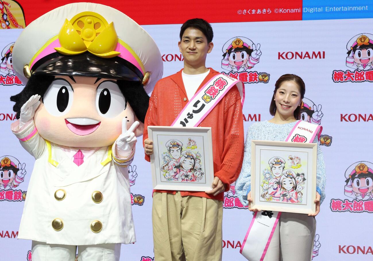 イベント会見でプレゼントされた似顔絵を手に笑顔の木原（左）と三浦