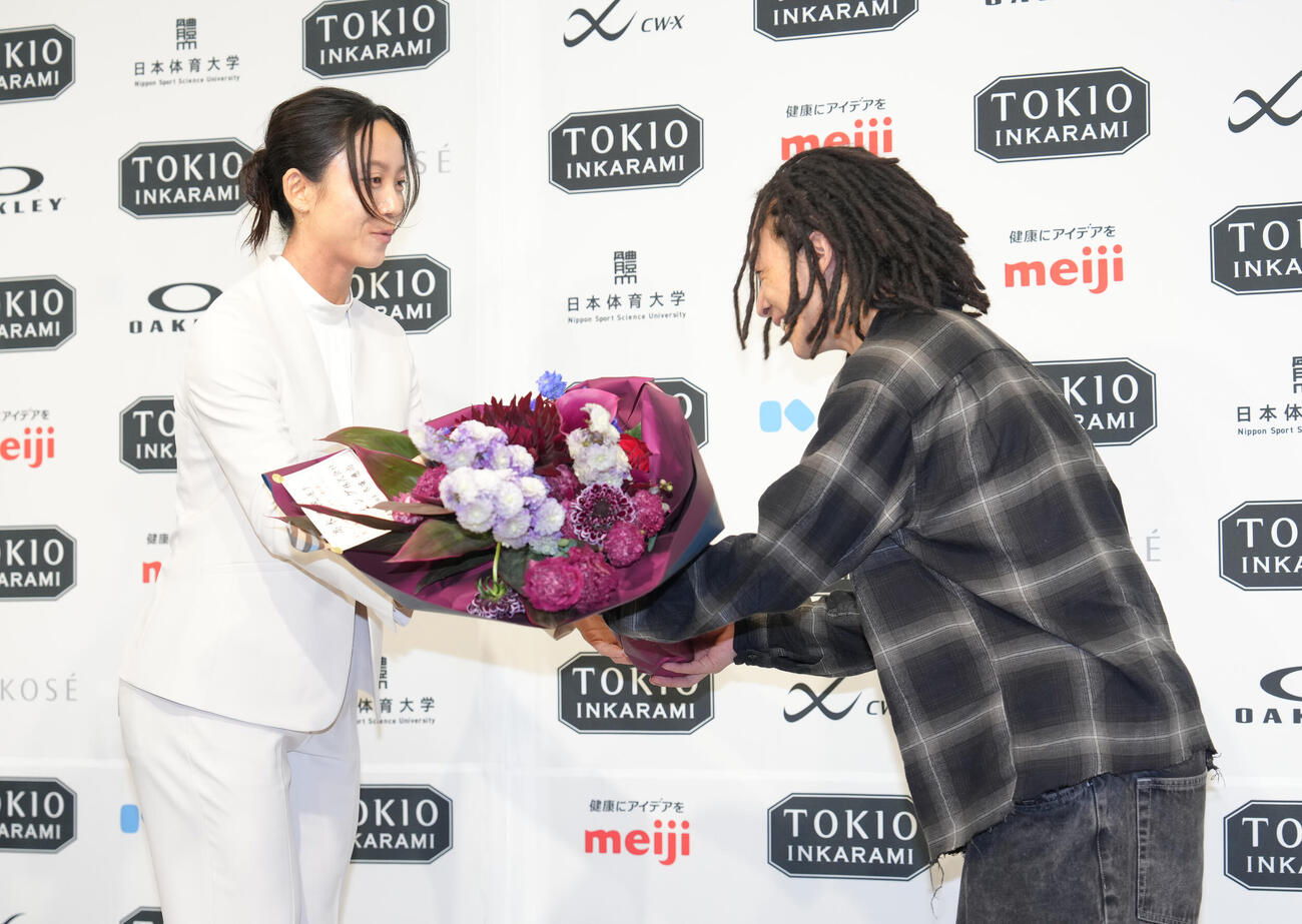 引退会見に臨んだ高木美帆（左）は平野から花束を受け取る（撮影・足立雅史）