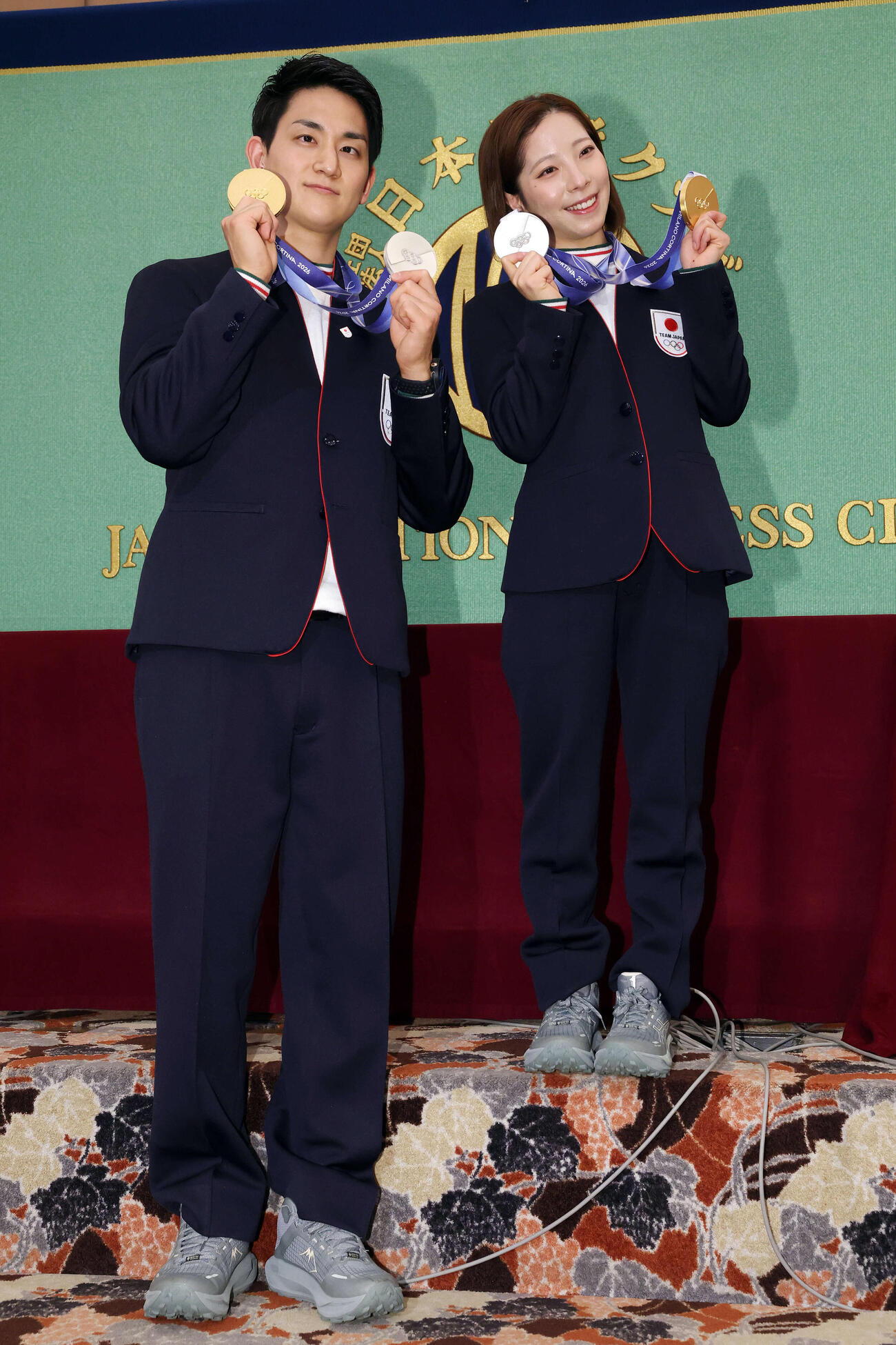 日本記者クラブの会見で記念撮影する木原（左）と段の上に立つ三浦（2026年2月25日）