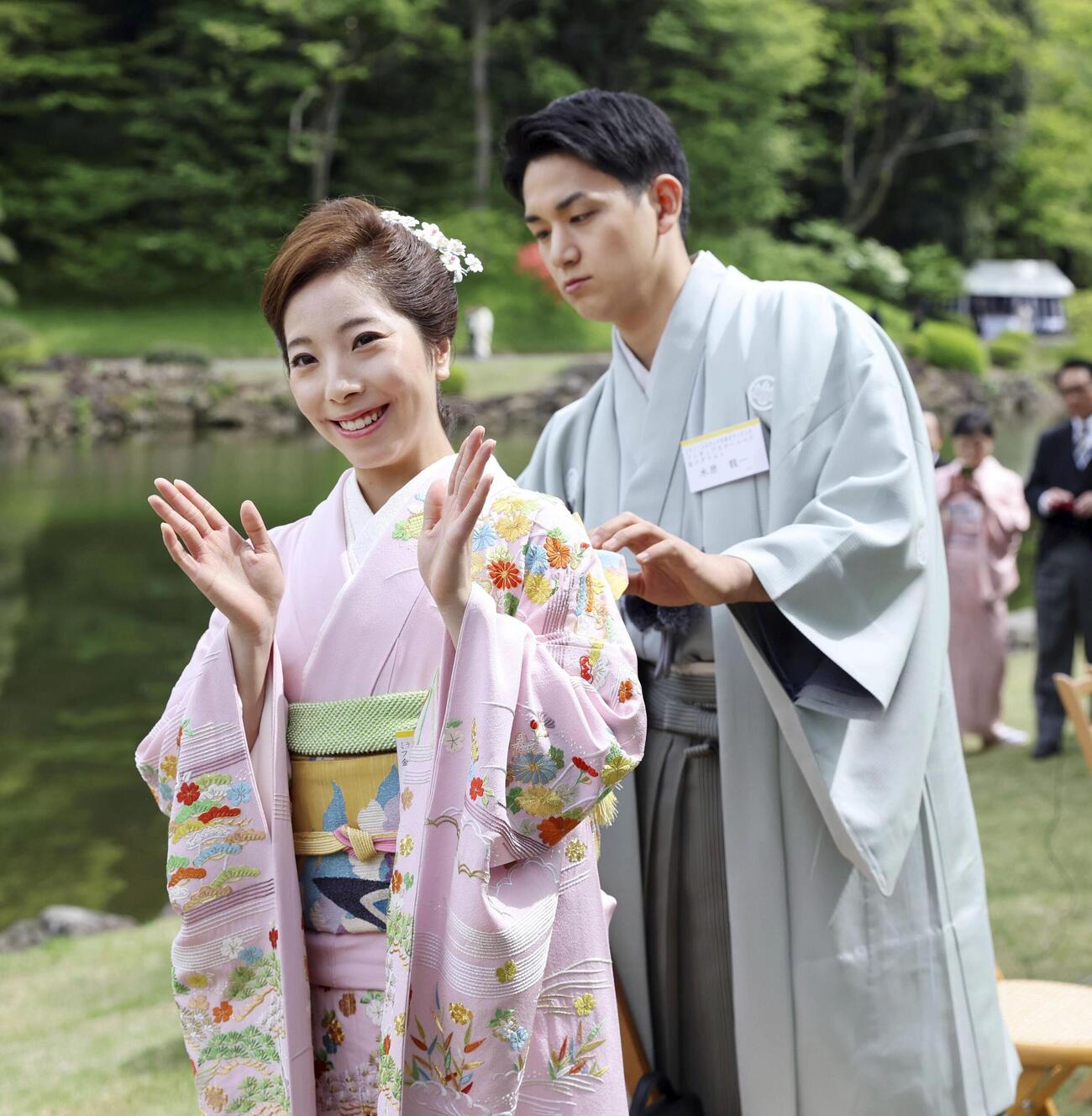 春の園遊会で三浦璃来（左）の帯を直す木原龍一（代表撮影）