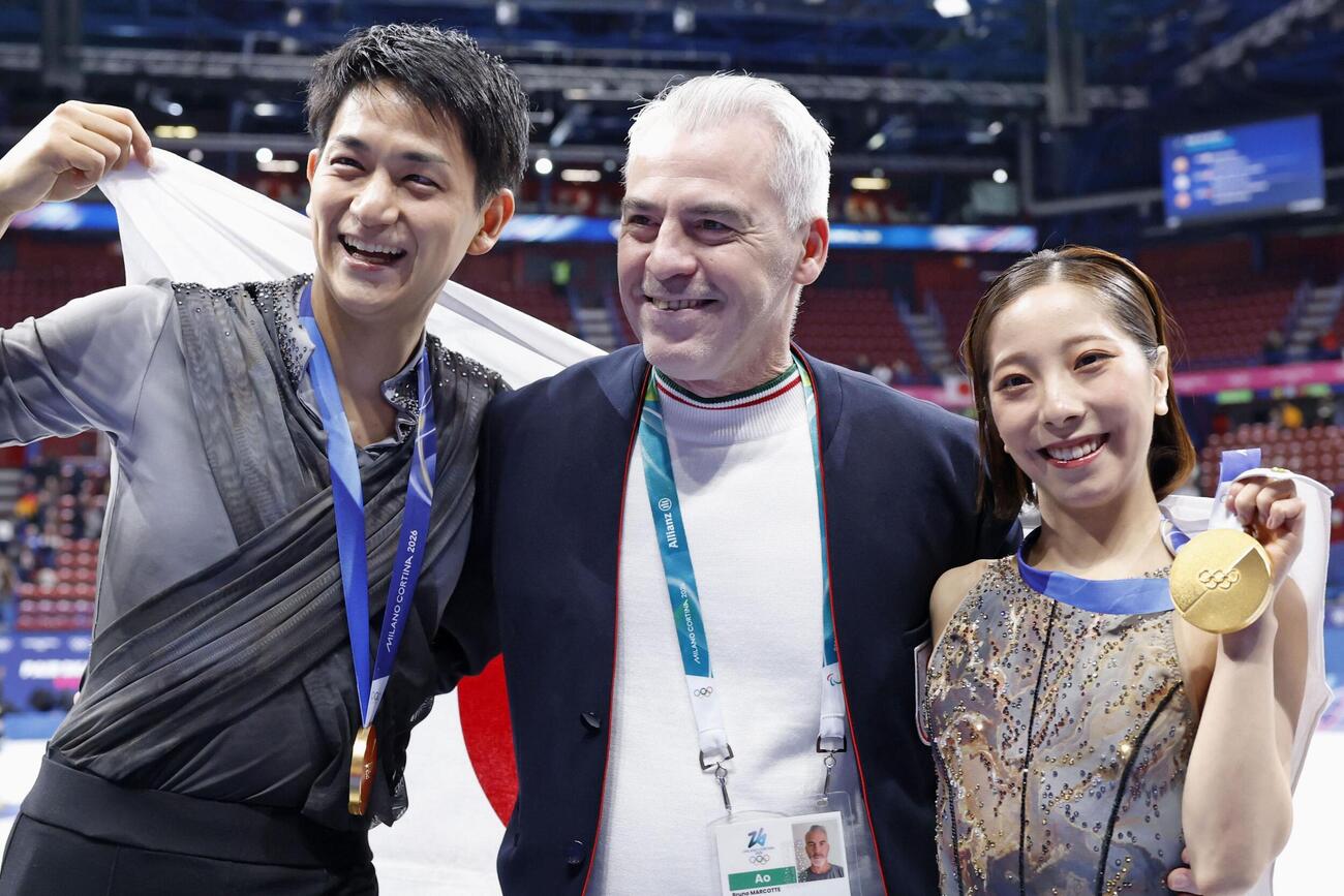 ミラノ・コルティナ冬季五輪のフィギュアスケートペアで金メダルを獲得し、ブルーノ・マルコット・コーチ（中央）と記念撮影する三浦璃来（右）、木原龍一組＝2月、ミラノ（共同）