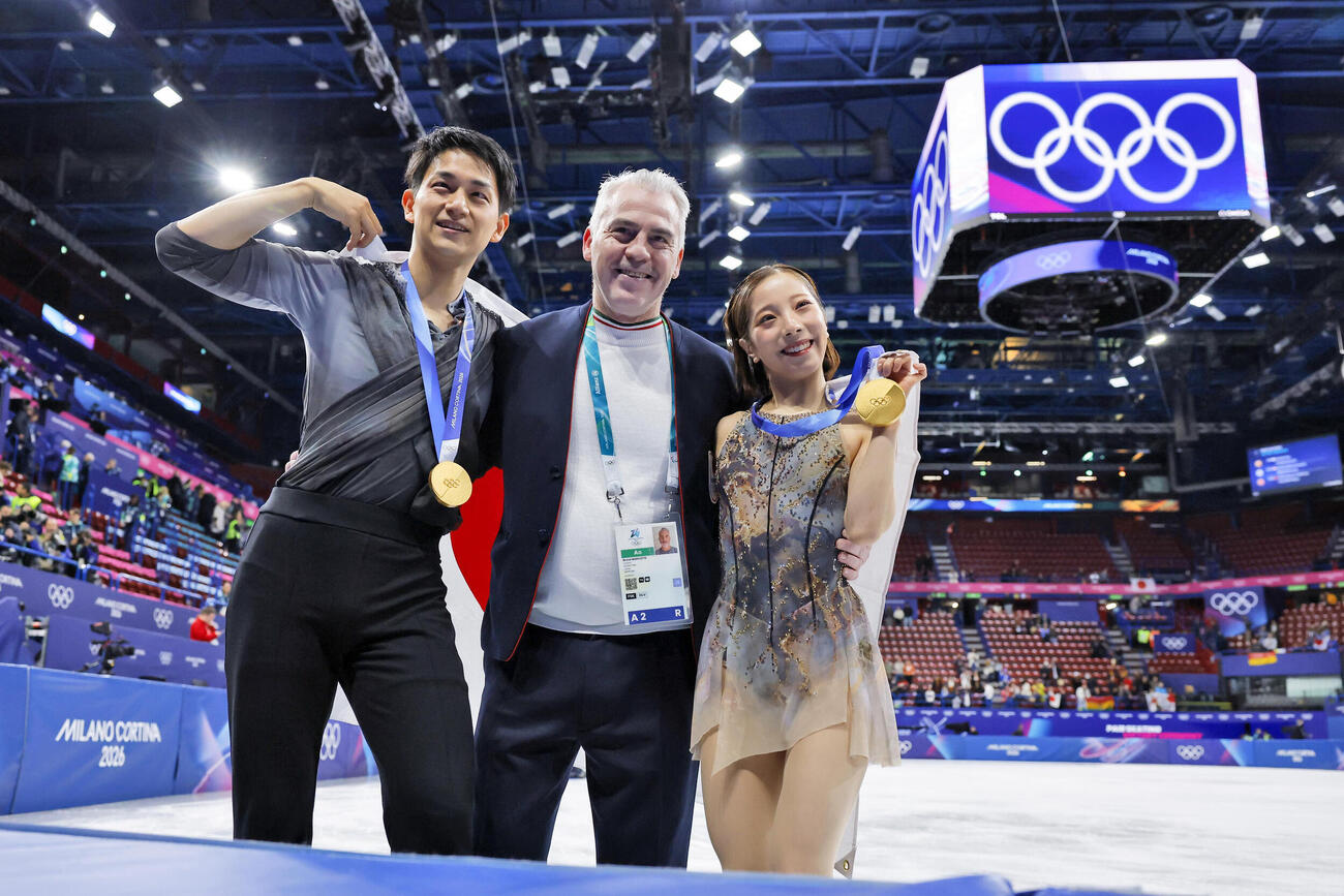 ミラノ・コルティナ冬季五輪のフィギュアスケートペアで金メダルを獲得し、ブルーノ・マルコット・コーチ（中央）と記念撮影する三浦璃来（右）、木原龍一組＝2月、ミラノ（共同）