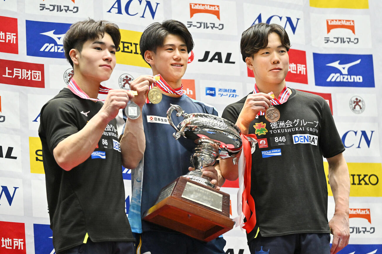 表彰式で記念撮影する優勝の橋本（中央）。左は2位の岡と3位の川上（撮影・滝沢徹郎）