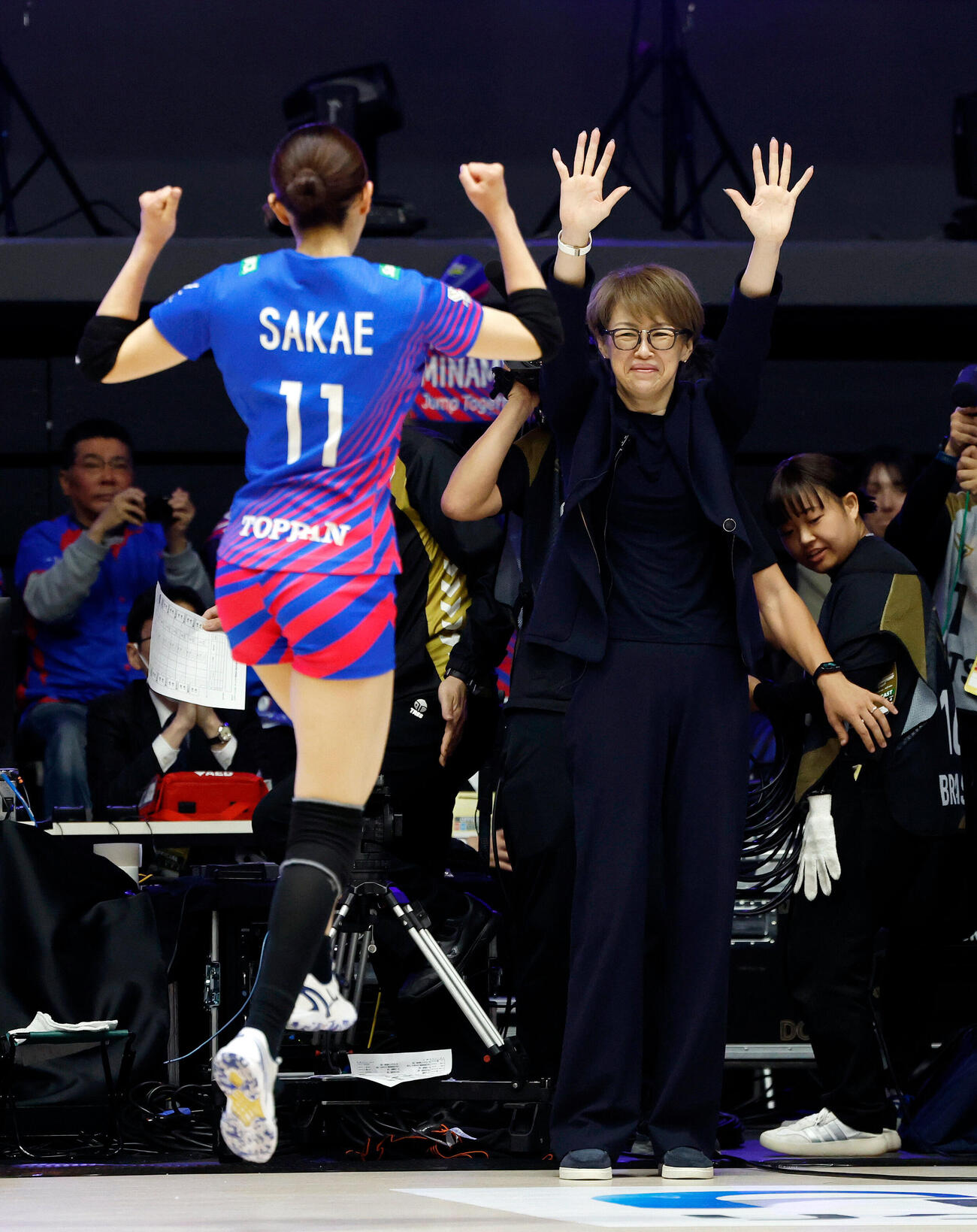 SAGA久光対大阪M　優勝を決めたSAGA久光中田久美ヘッドコーチ（右）は両手を挙げ、選手を迎え入れる（撮影・山本朝陽）