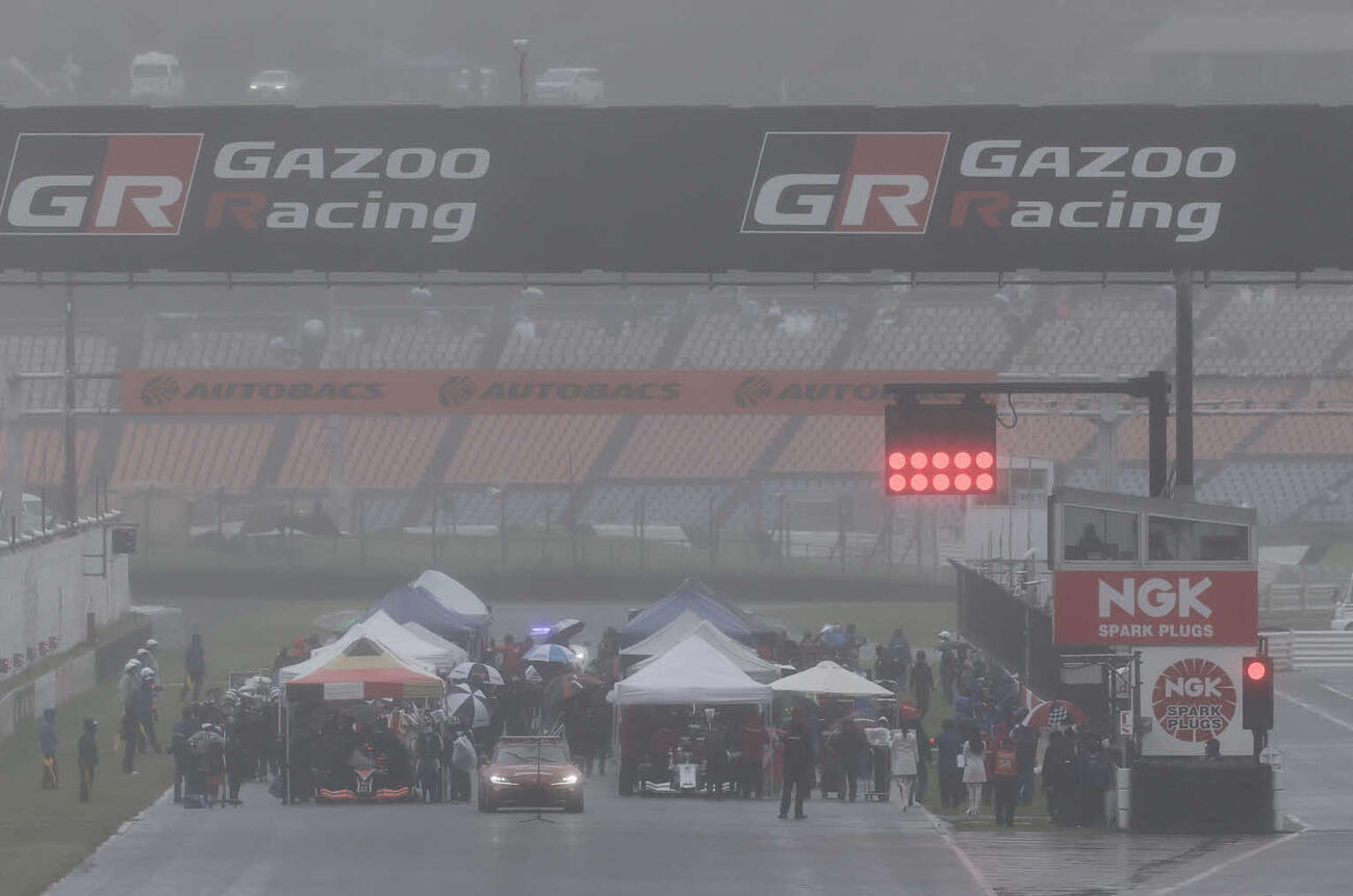 スーパーフォーミュラ第3戦　強い雨と霧が立ちこめる中、グリッド上にテントを張って待機する各ドライバー（JRP提供）＝2026年4月26日、大分県日田市のオートポリス