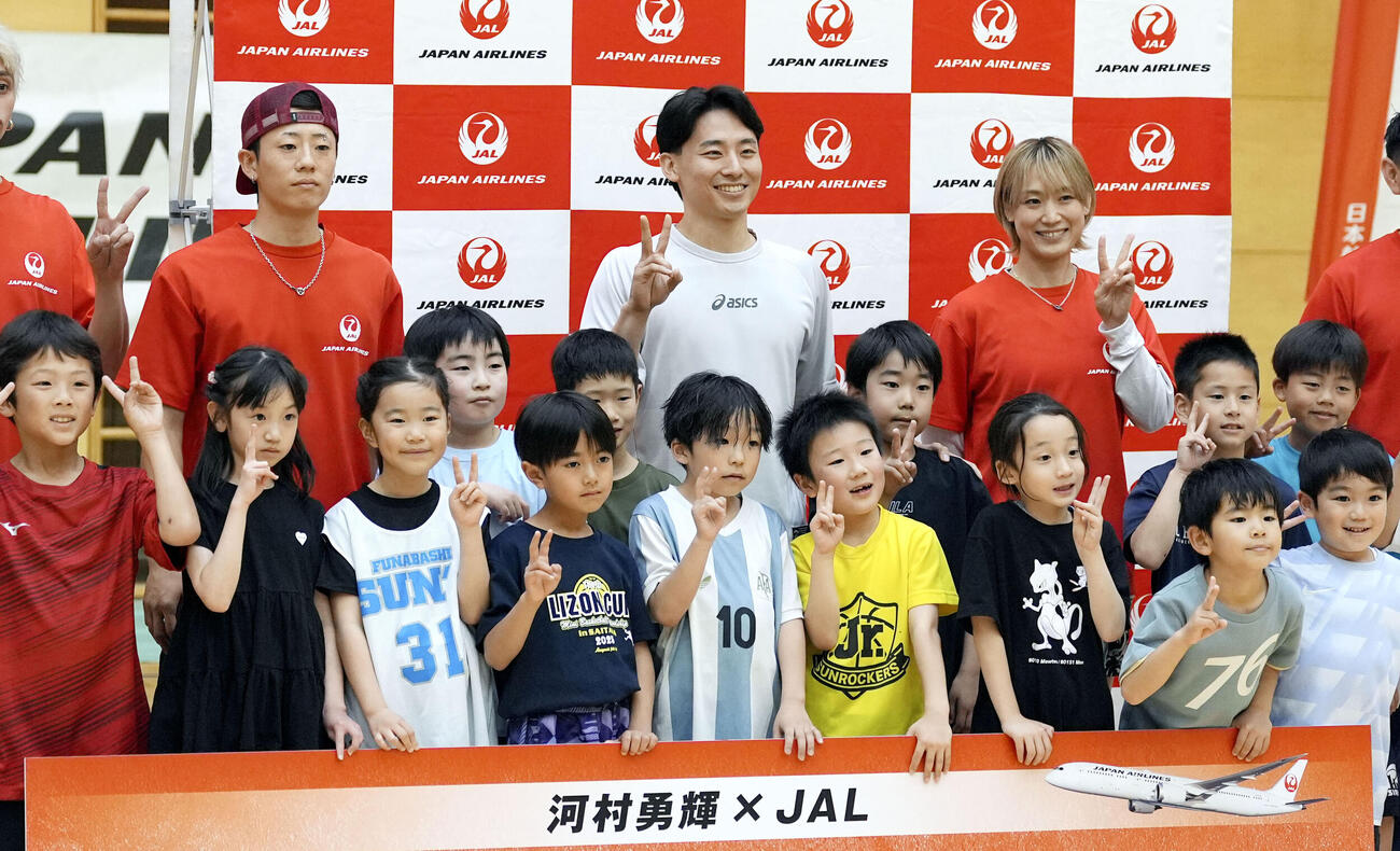バスケ教室に参加した子どもたちとポーズをとる河村勇輝（後列中央）＝東京都内(共同)
