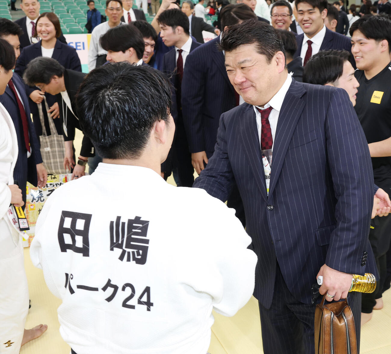 全日本選手権を制した田嶋剛希（左）と笑顔で握手する吉田秀彦総監督（撮影・宮地輝）