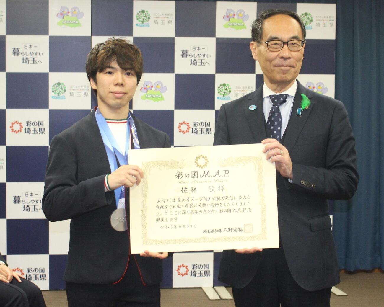 成果報告会で写真に納まる佐藤駿（左）と大野元裕埼玉県知事