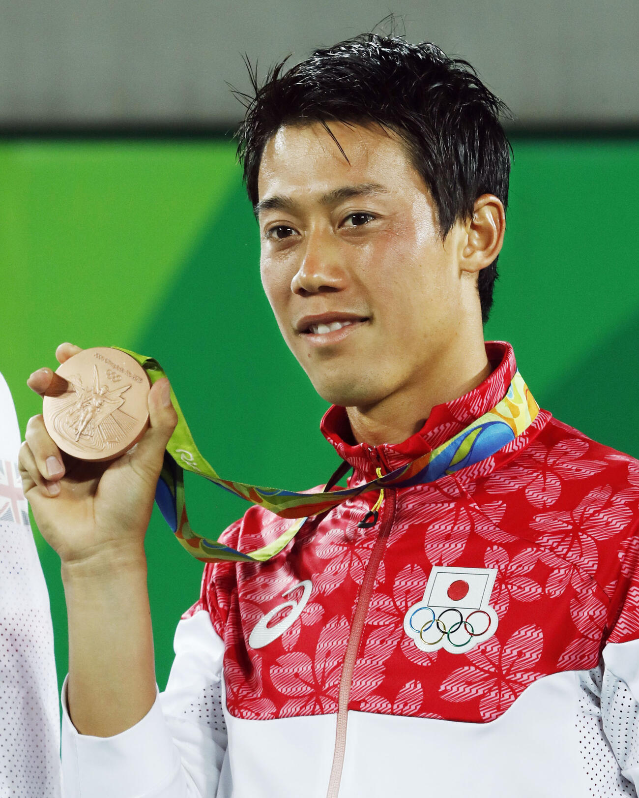2016年8月、リオデジャネイロ五輪のテニス男子シングルスで3位となり、表彰式で銅メダルを掲げる錦織圭（共同）