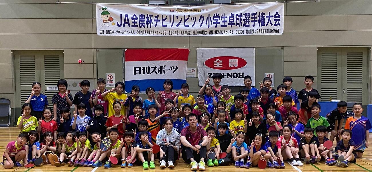 ゲストの石川佳純さん（中央）と一緒に記念撮影におさまる横浜オープン小学生卓球選手権大会参加者