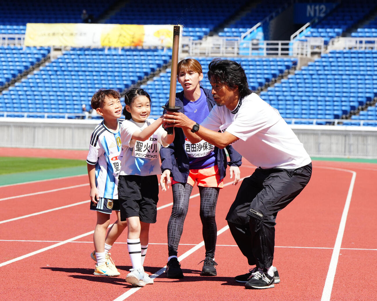 JA全農　チビリンピック2026の開会式で聖火リレーを行う中沢佑二さん（右端）と吉田沙保里さん（中央右）（撮影・江口和貴）