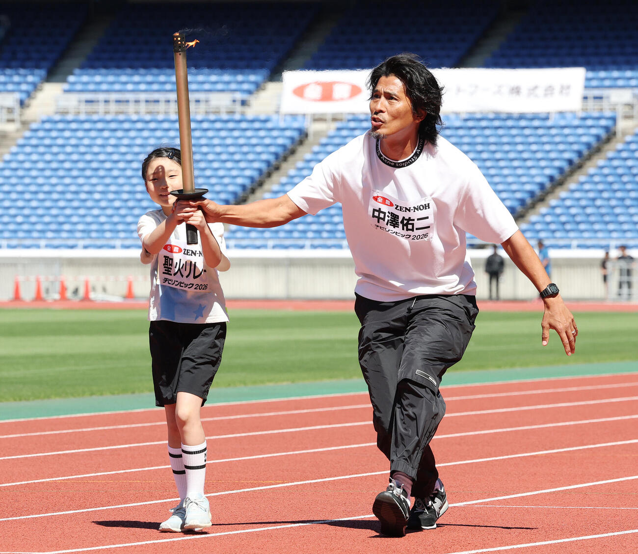 JA全農杯チビリンピック2026　子どもと聖火リレーする中沢佑二さん（撮影・宮地輝）