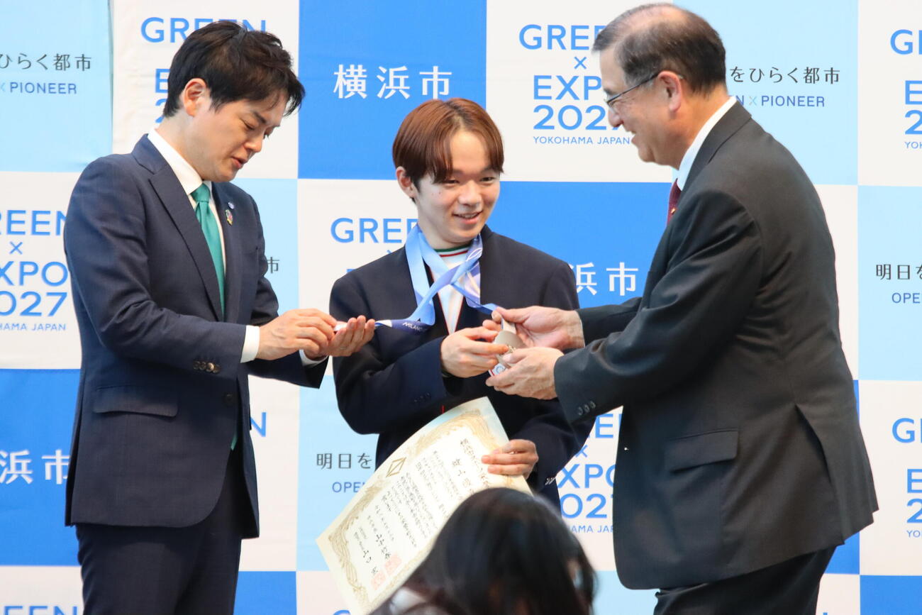 横浜市スポーツ栄誉賞を贈呈されたフィギュアスケート男子の鍵山優真はメダルを披露する（撮影・保坂果那）