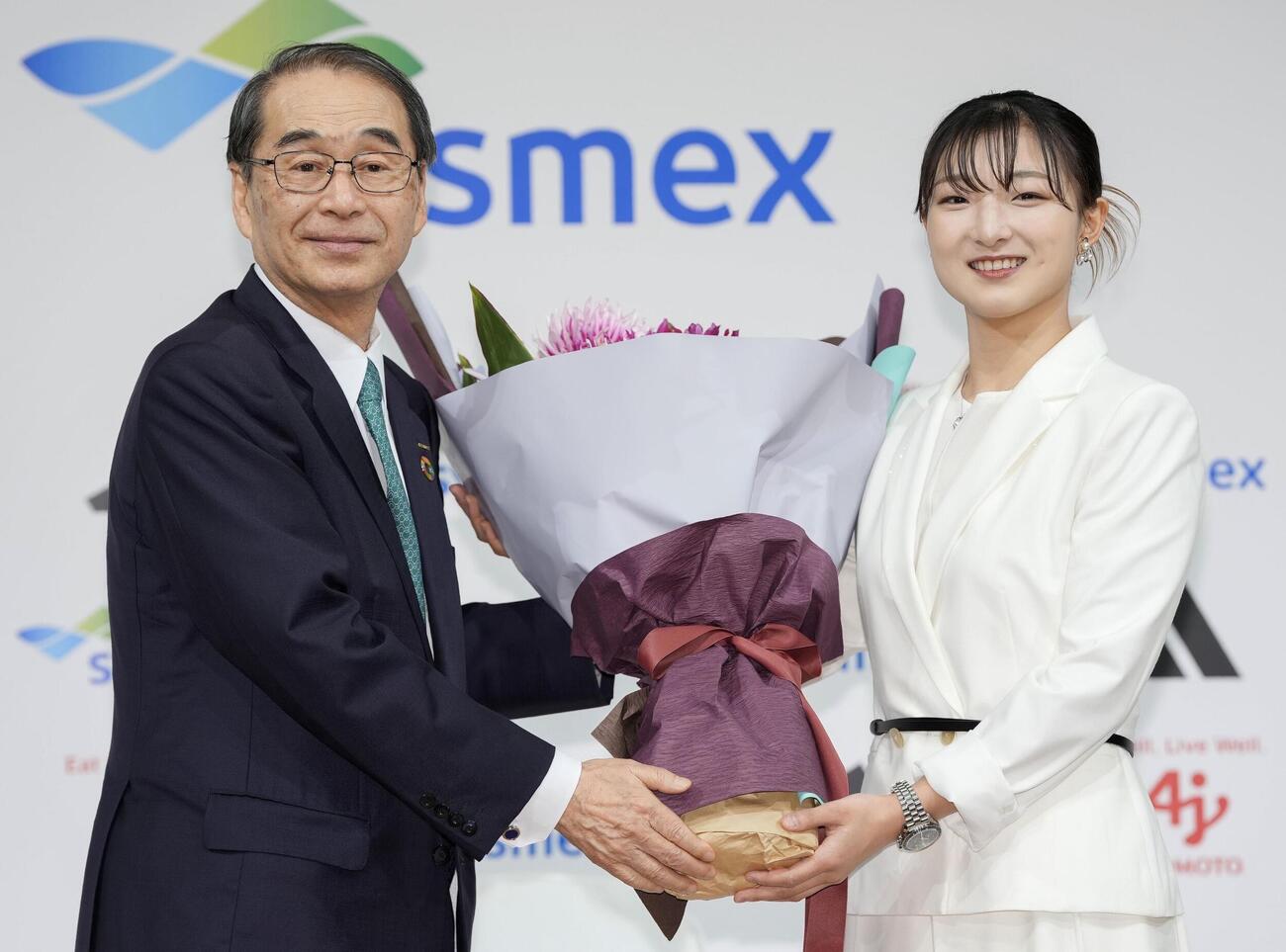 現役引退の記者会見で、花束を受け取るフィギュアスケート女子の坂本花織（右）＝13日午前、神戸市内のホテル（共同）