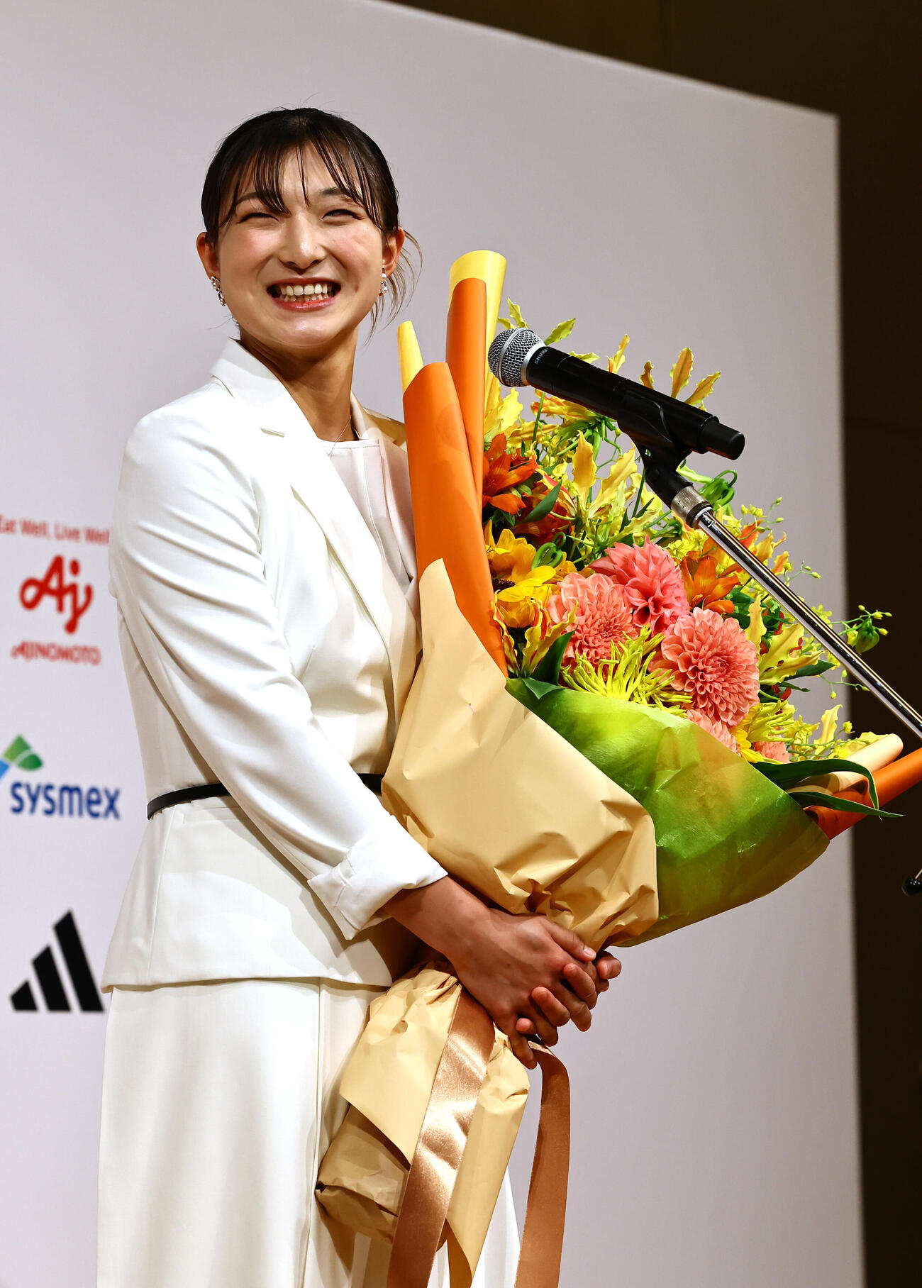 引退会見で結婚を発表した坂本花織は花束を手に笑顔を見せる（撮影・上田博志）