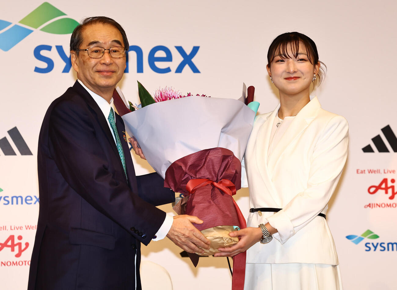 シスメックス株式会社代表取締役会長の家次恒氏（左）から花束を受け取る坂本花織（撮影・上田博志）