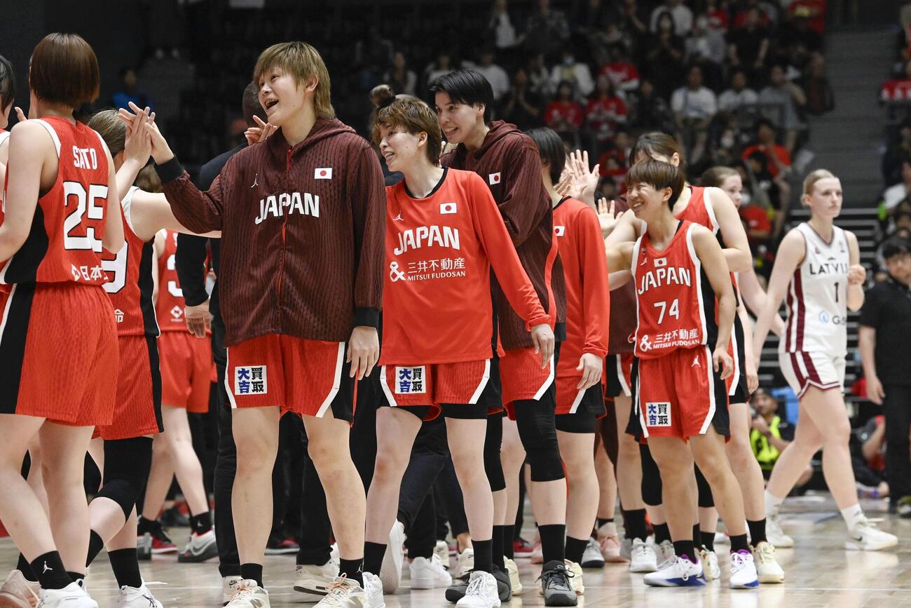 ラトビアに勝利し、タッチを交わす高田（左から2人目）ら日本の選手たち（共同）