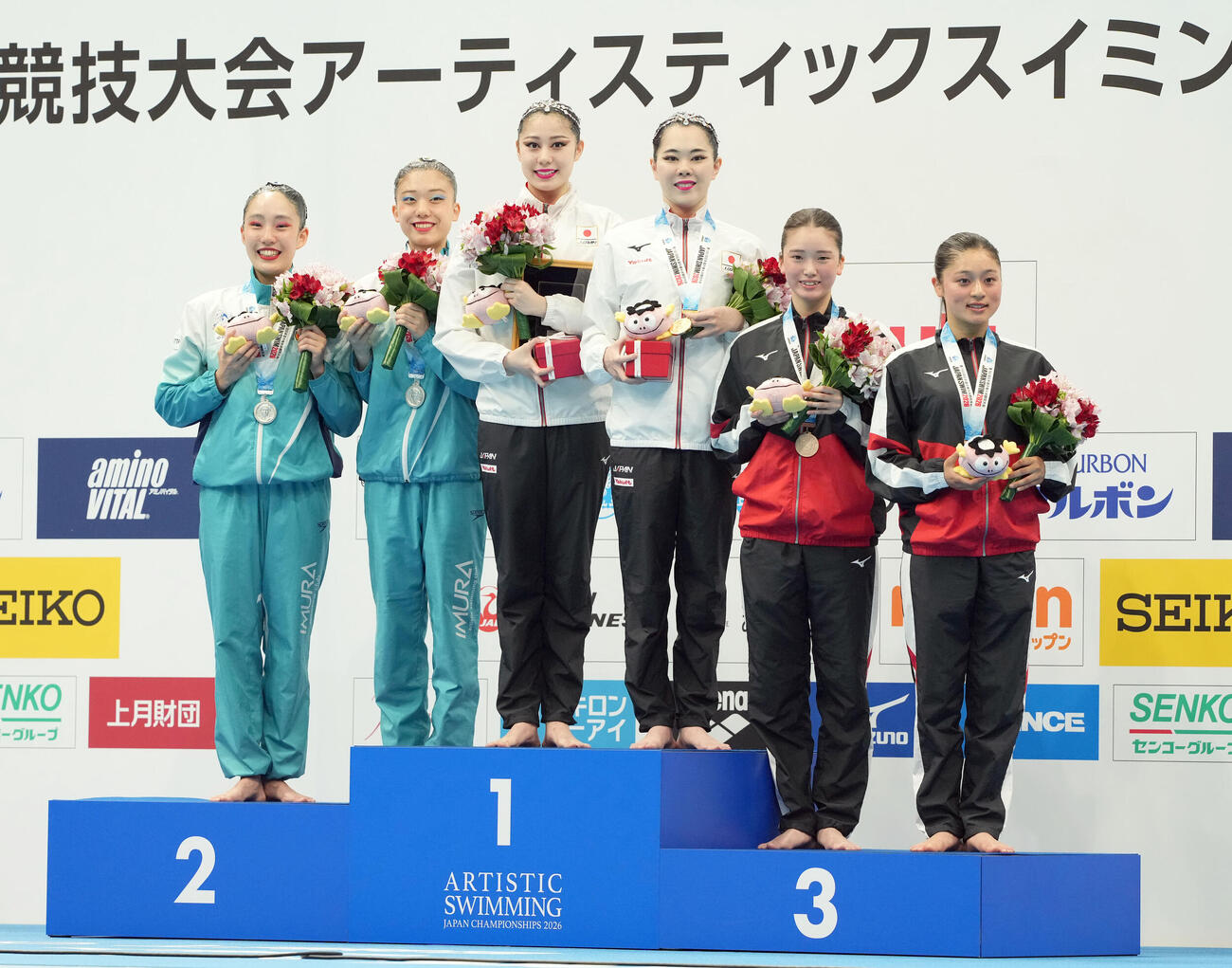 女子デュエット　テクニカルルーティーン　表彰台で笑顔を見せる、優勝した比嘉もえ・佐藤友花組、左から2位の額田紗子・田所新菜、2人おいて3位の小埜心咲・竹岡小夏組（撮影・たえ見朱実）＝2026年5月22日