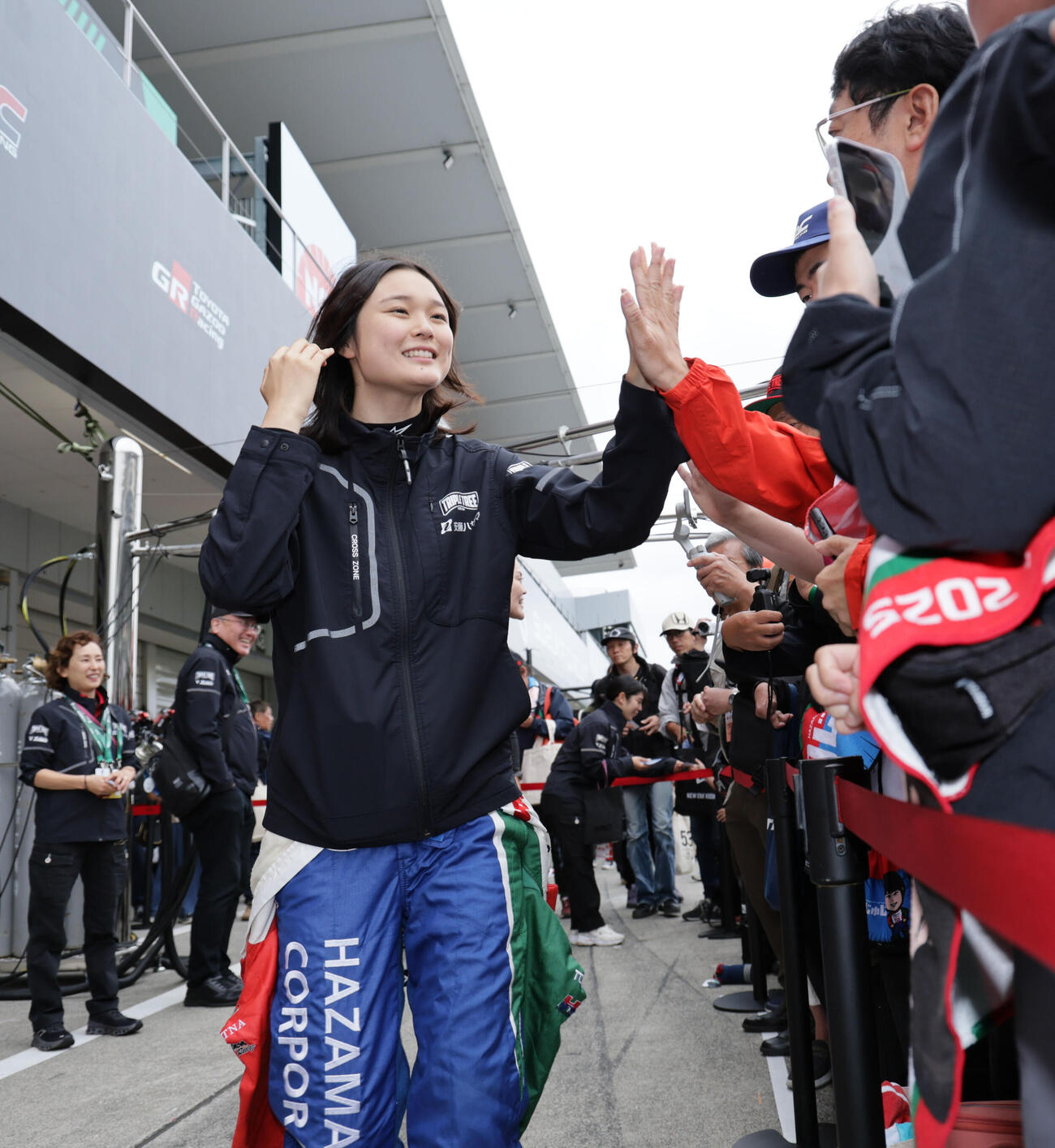 スーパーフォーミュラ第4戦ピットウォークでファンとハイタッチするHAZAMA ANDO Triple Tree RacingのJuju（野田樹潤）（撮影・宮崎幸一）