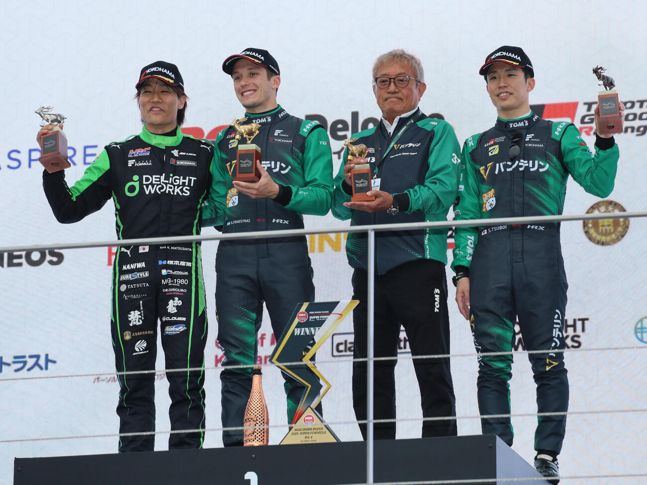 スーパーフォーミュラ第4戦の表彰式でトロフィーを掲げる、左から2位の松下信治、優勝したサッシャ･フェネストラズ、舘信秀監督、3位の坪井翔（撮影・宮崎幸一）＝2026年5月23日